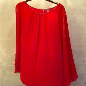 Red Vince Camuto blouse with bell sleeves.